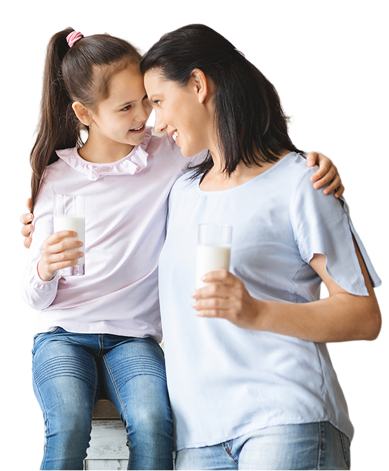 Madre e hija sosteniendo vasos de leche sonriendo y abrazadas